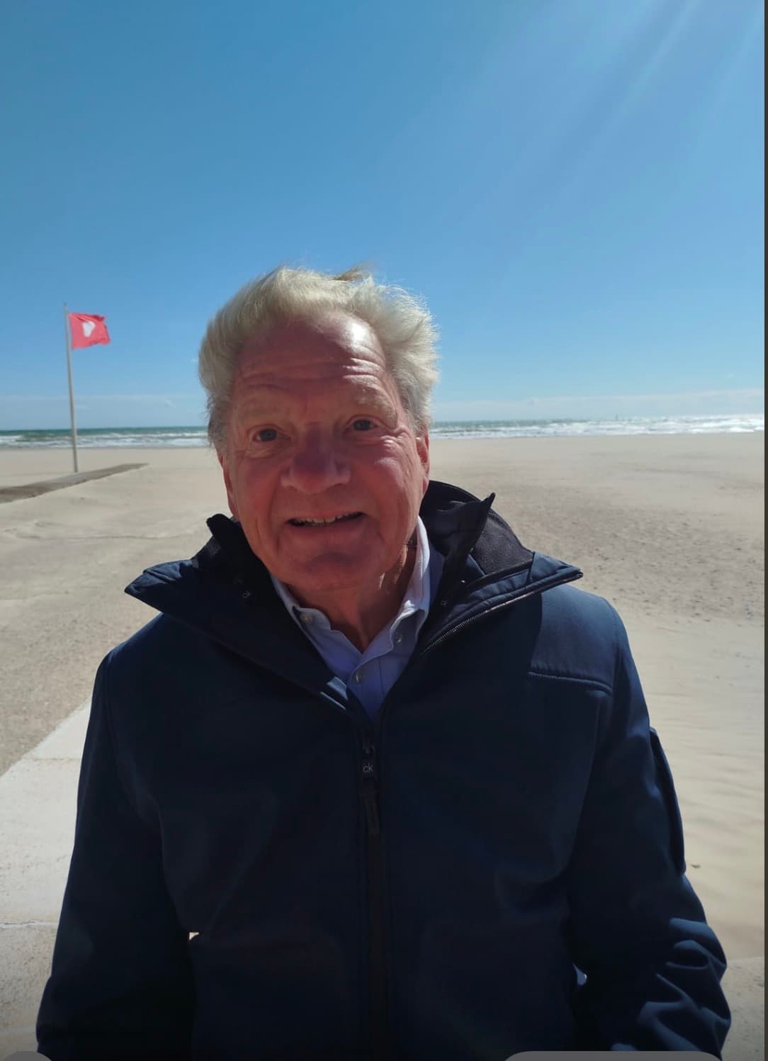 Martin Feijen smiling on a sunny beach in a blue jacket